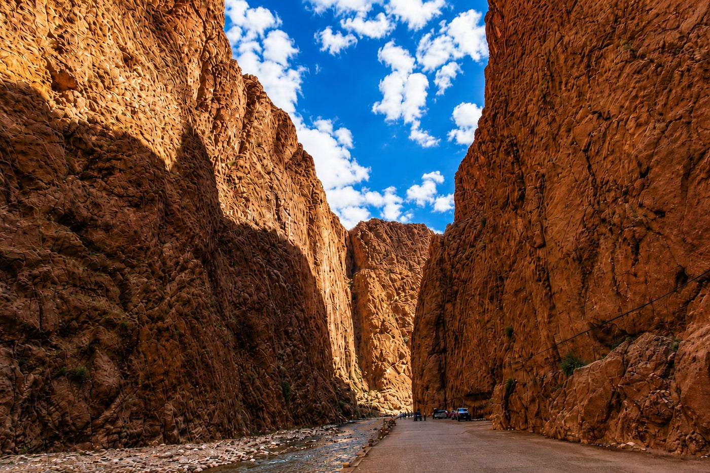 The towering rock walls of the Todra gorge above a narrow road, southern Morocco.
