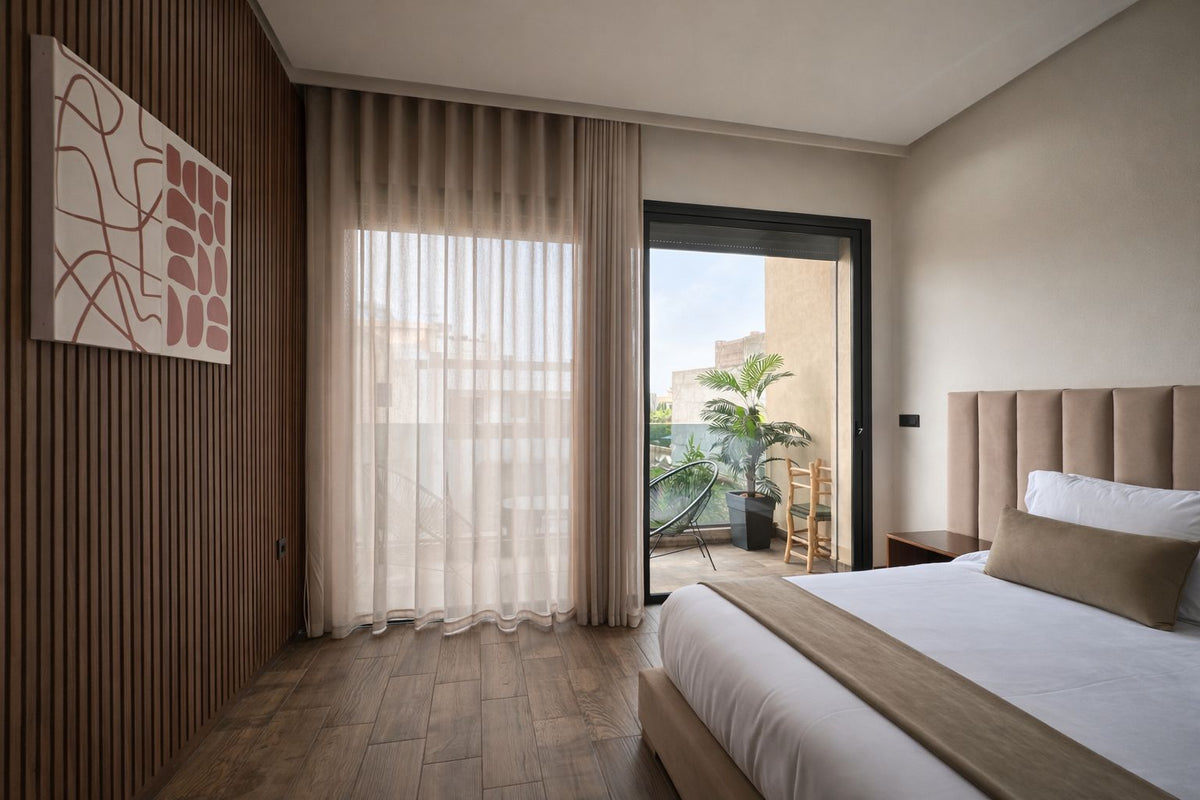 A calm bedroom with wood panelling and sheer curtains