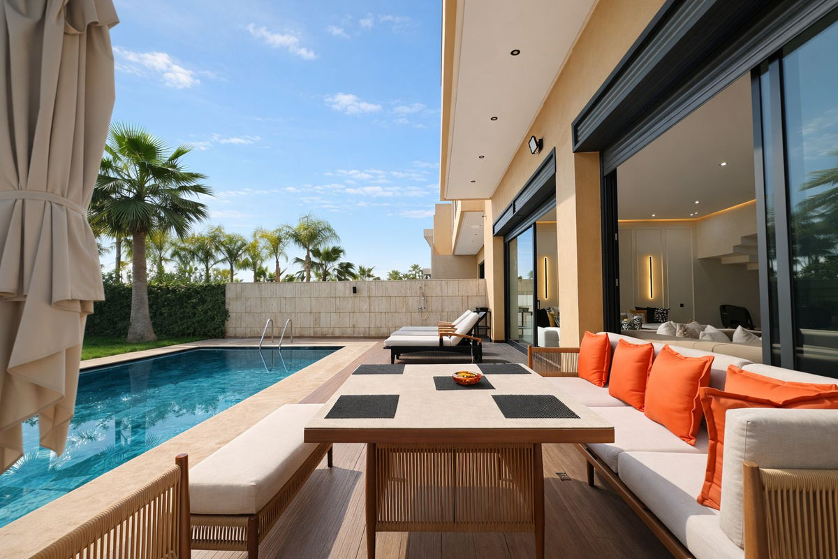 A pool terrace with an outdoor dining table and orange cushions
