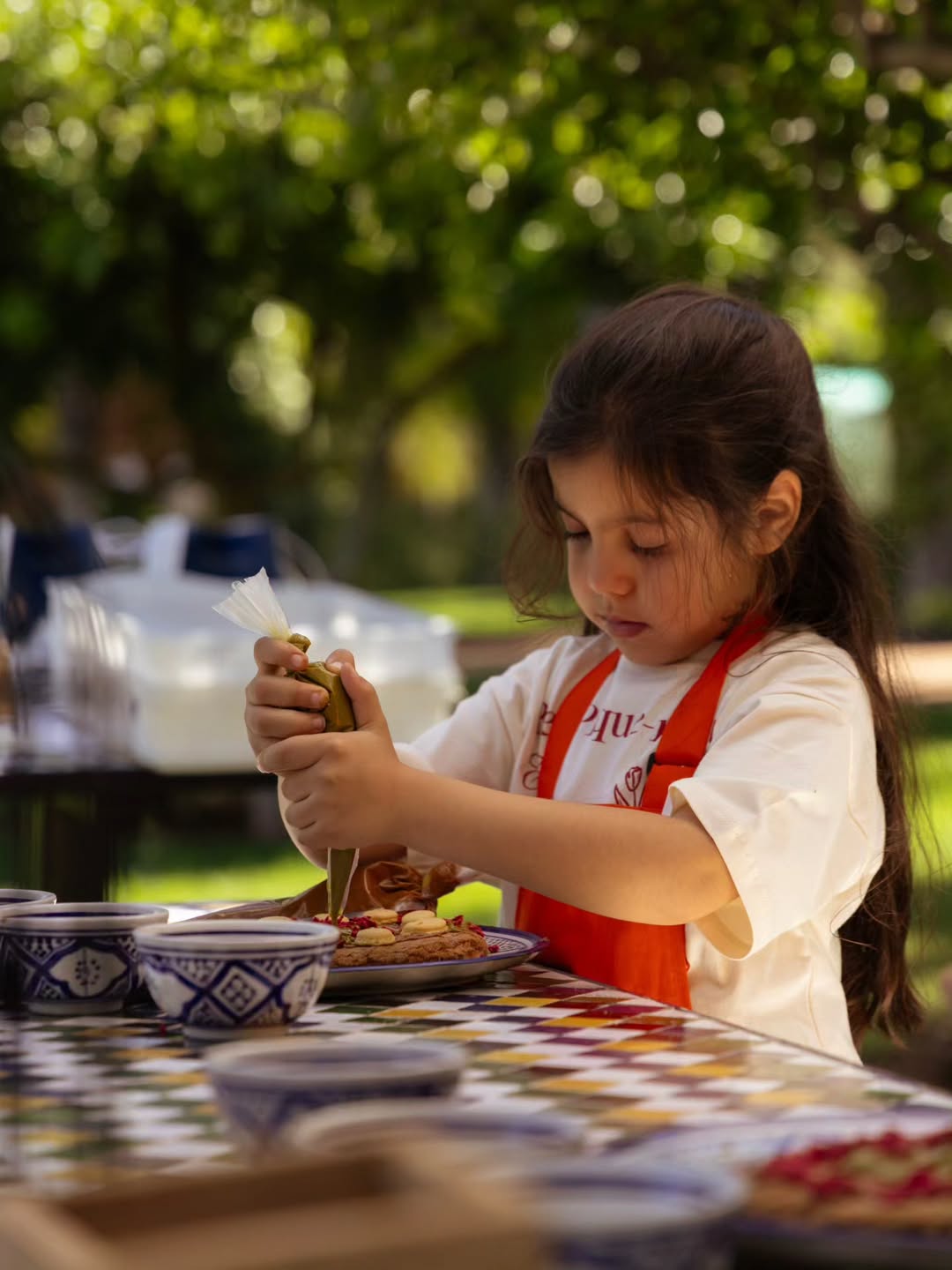 A child pressing glazed tile chips into plaster to make a mosaic in Marrakech, Morocco.
