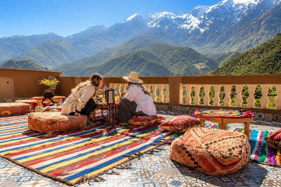 Private day with an Amazigh family in the High Atlas - a flat-roofed home with woodsmoke against terraced mountain slopes, Morocco.