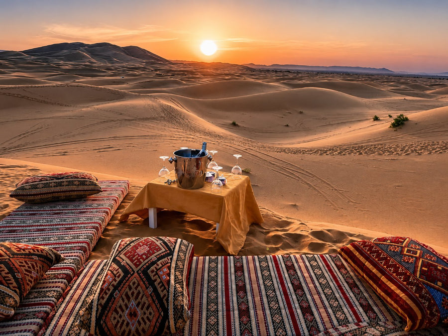 The Erg Chebbi dunes at dawn near Merzouga with a quiet luxury desert camp, Moroccan Sahara.