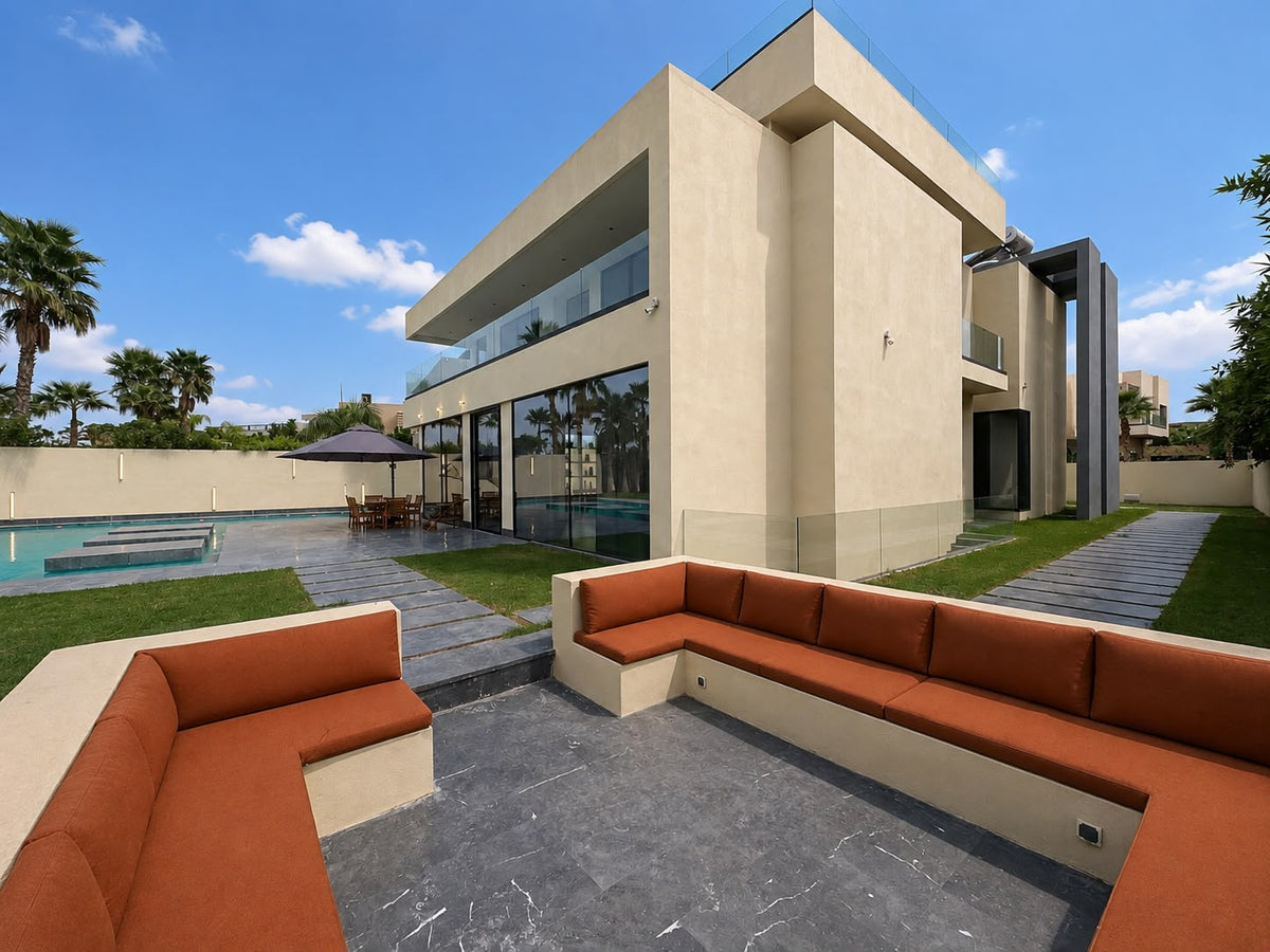 An outdoor lounge with terracotta cushions beside the pool