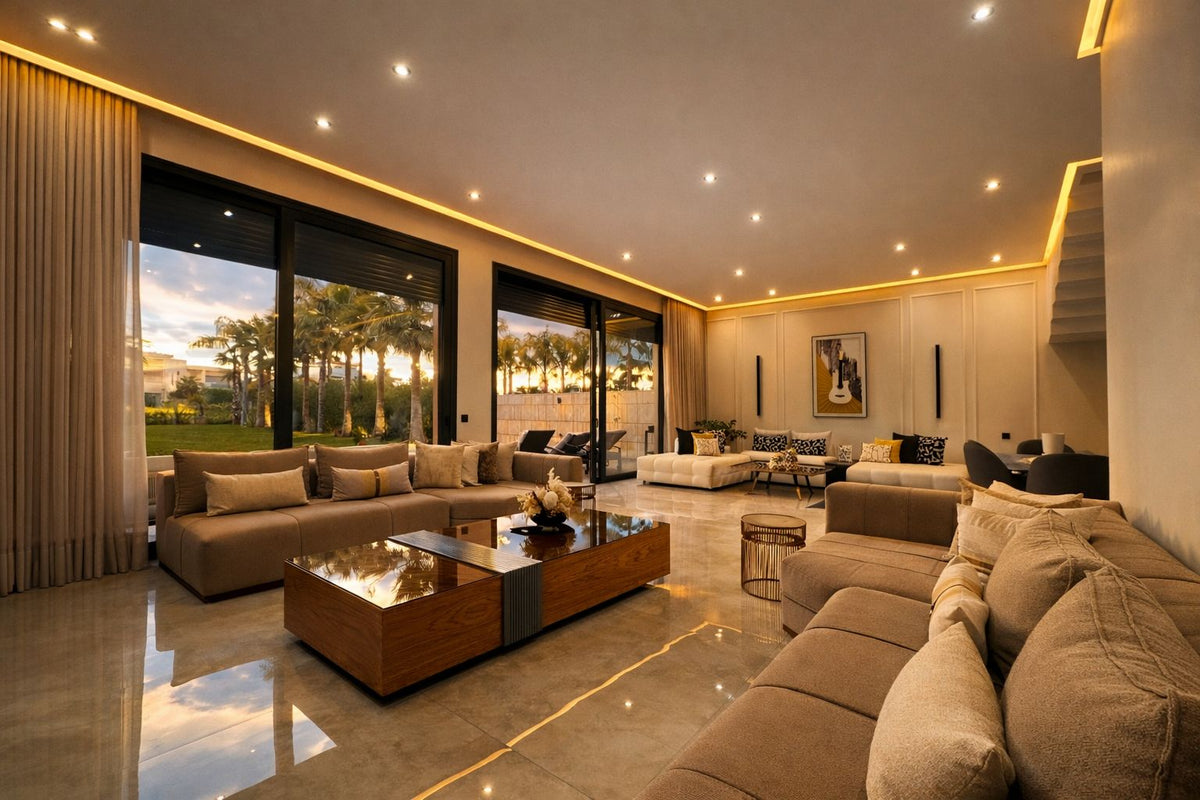 A wide lounge with deep sofas and tall windows onto the garden