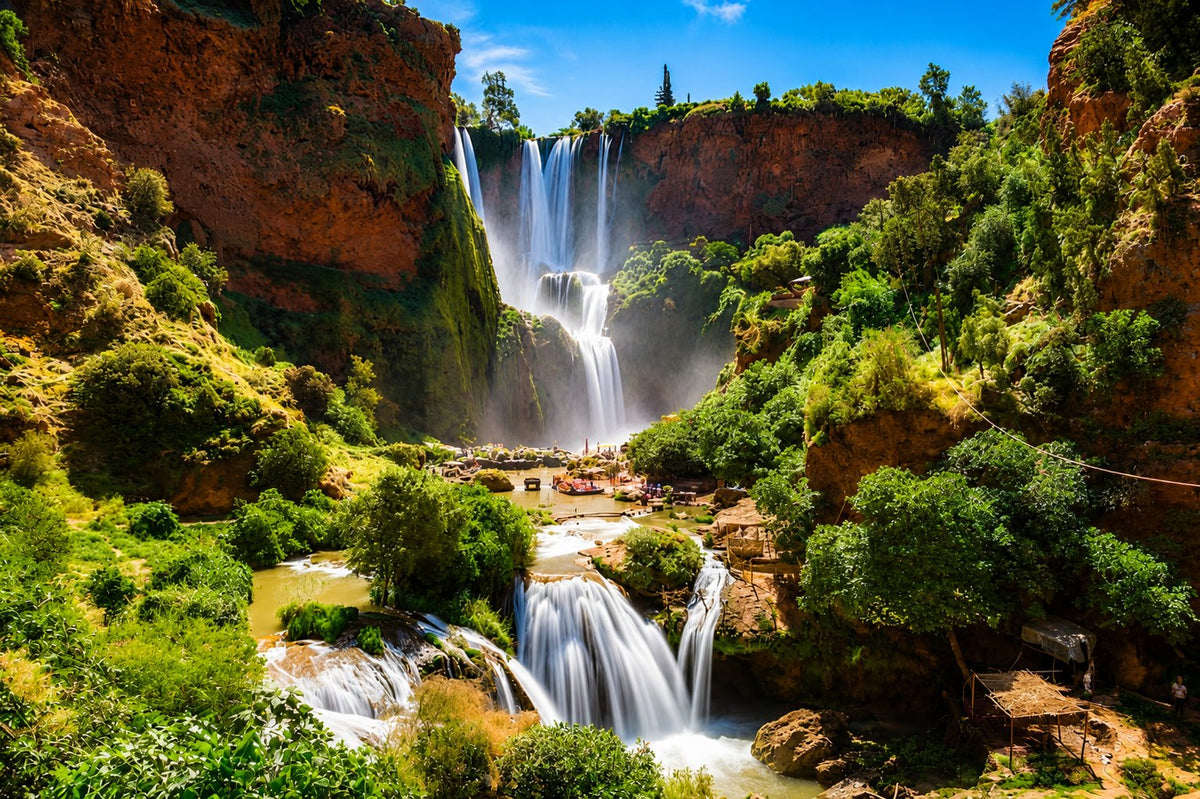 Ouzoud waterfalls dropping over red cliffs into a green gorge